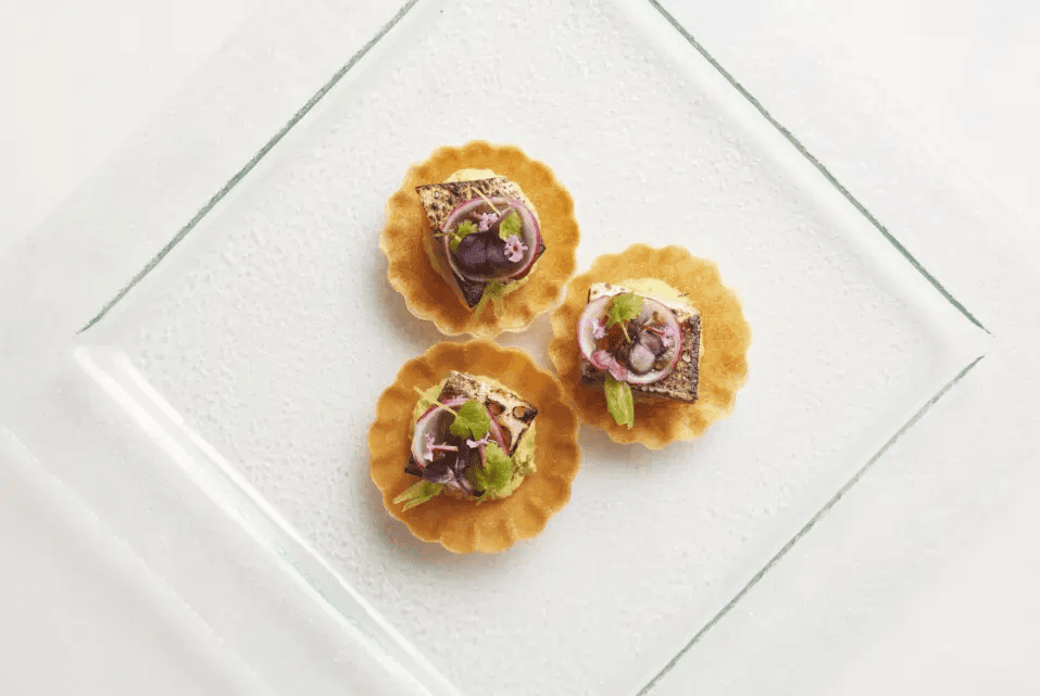 Trio of canapes contrasted on a square white dish.